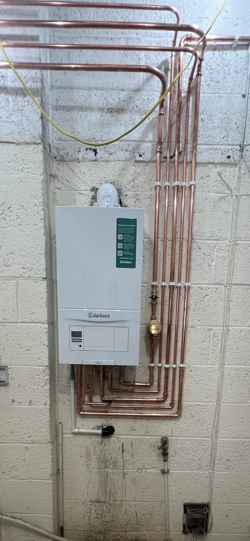 Vaillant boiler installed by MCH Heating with fresh copper pipework across the plant room wall